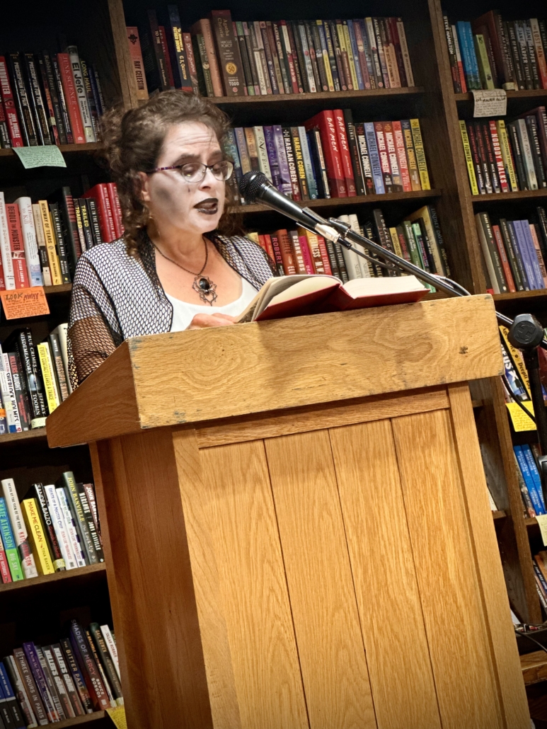 Author Silvia Acevedo in costume at a podium during her author visit, reading her spooky story from THE HAUNTED STATES OF AMERICA